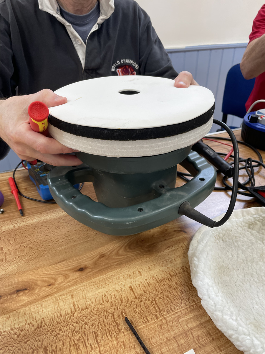 An opened household appliance being examined on a table during Repair Café