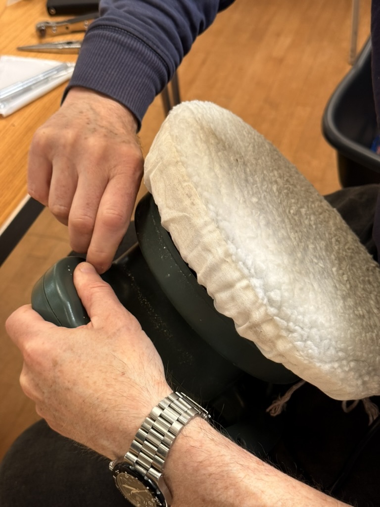 A car polisher opened up with tools and small parts on the table