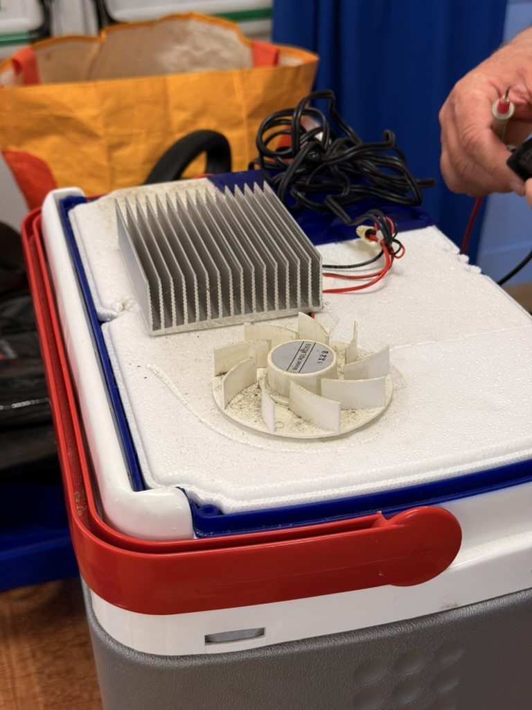 An electric cool box with its parts exposed during inspection