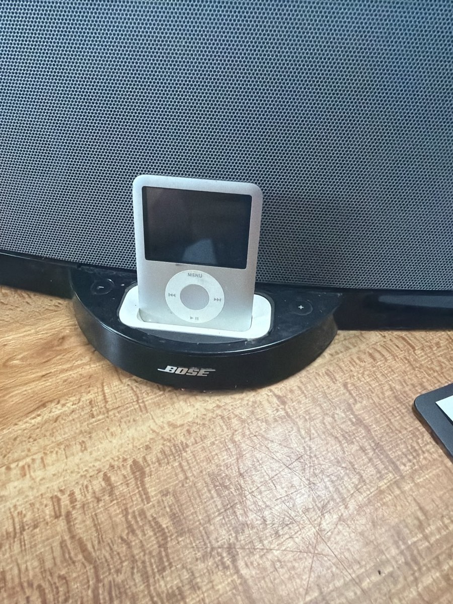An iPod seated in a Bose speaker dock on the table
