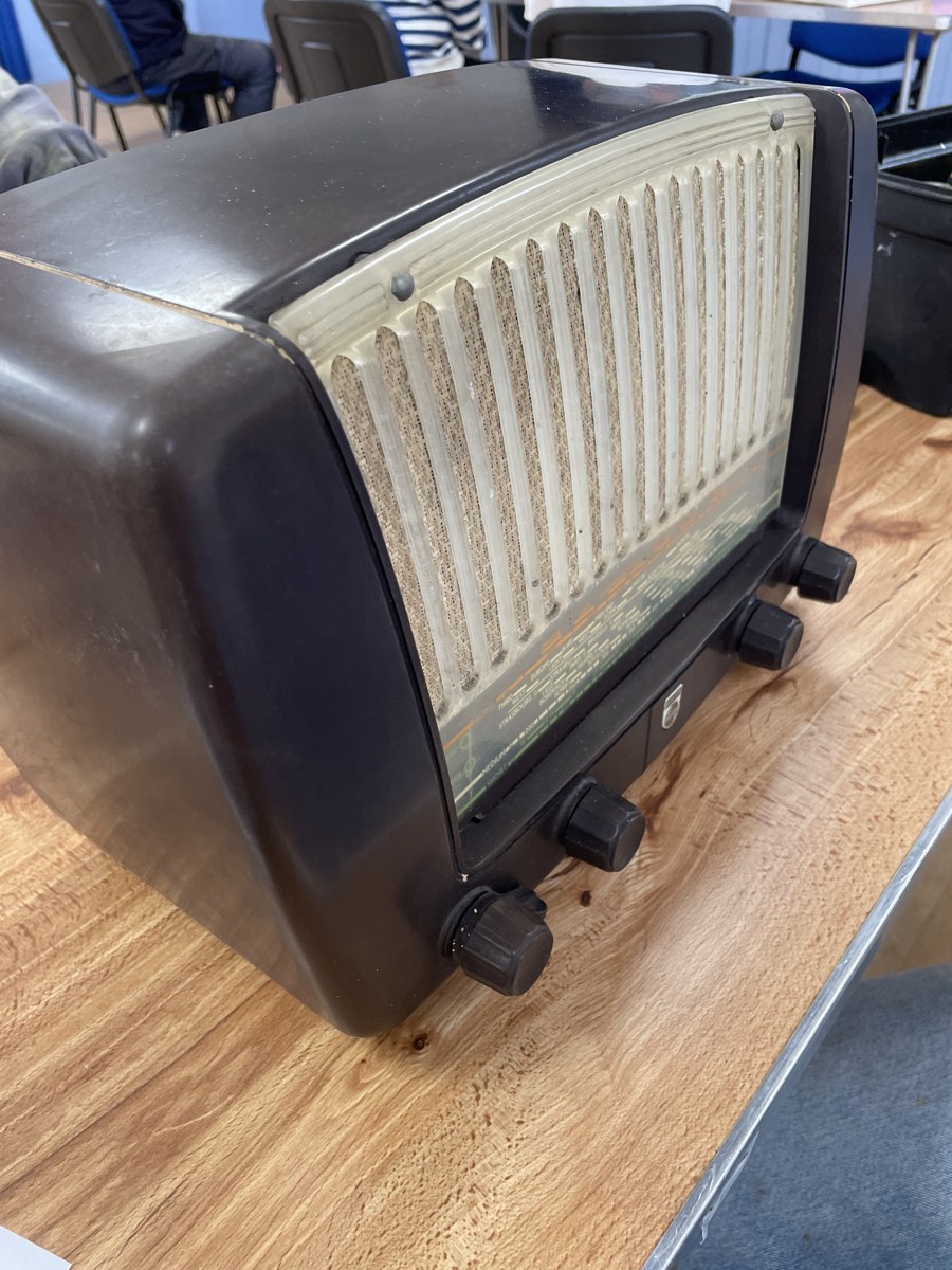 A vintage tabletop radio with a cream grille and tuning scale